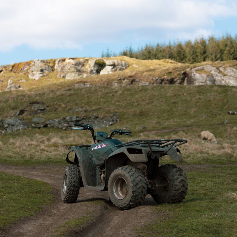 a truck that is sitting on a rock in the middle of a field