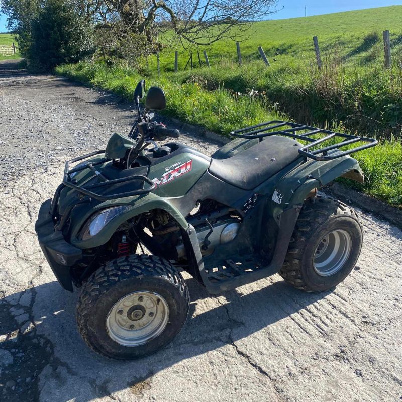 a motorcycle parked on the side of a dirt road