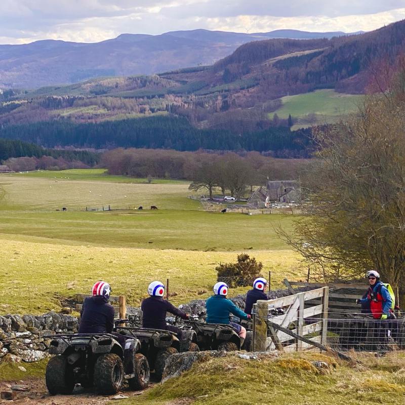 a group of people sitting in a field with a mountain in the background