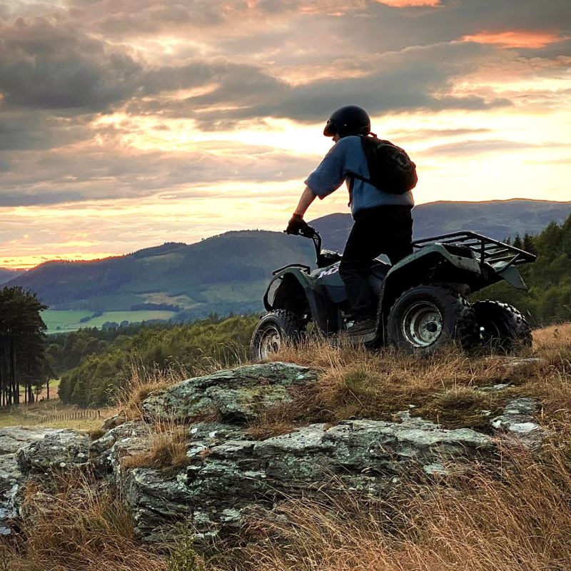 a man sitting on a grassy hill
